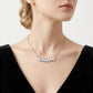 Model wearing staggered baguette moissanite bar necklace on collarbone.