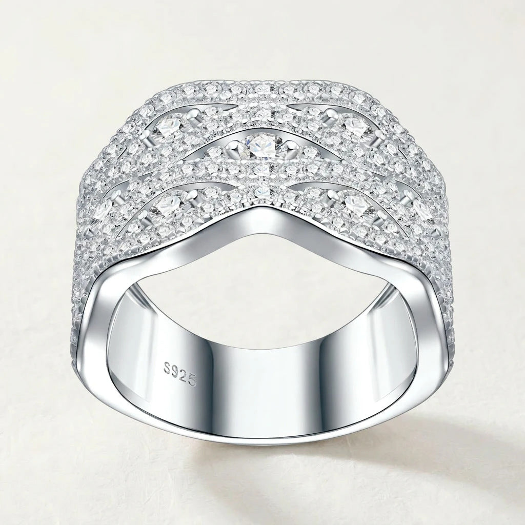 Studio front display of sterling silver wide wave pave moissanite crossover statement ring showing symmetric fluid curves.