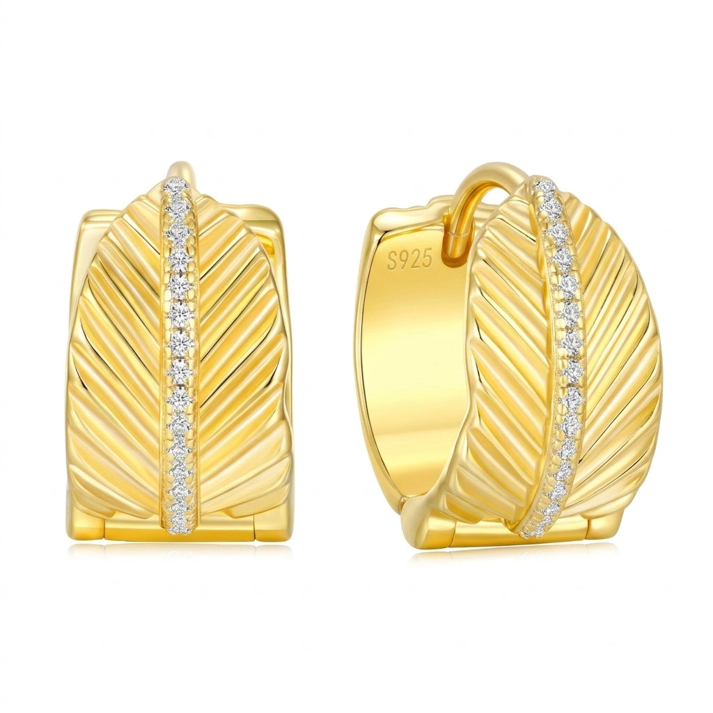 Pair of textured leaf gold chunky huggie earrings with a pavé moissanite center line on white background.