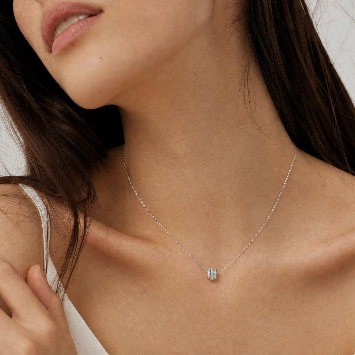 Model wearing three ring princess and round cut lab grown diamond barrel pendant necklace