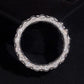 Front view of three row watch link moissanite wide band ring on dark background