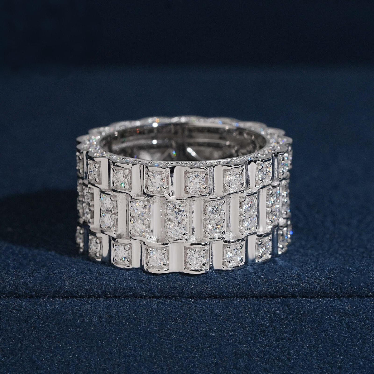 Three row watch link moissanite wide band ring in sterling silver on dark blue box