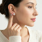Editorial fashion lookbook portrait of a model styling timeless romantic gold heart-cut moissanite clover stud earrings.