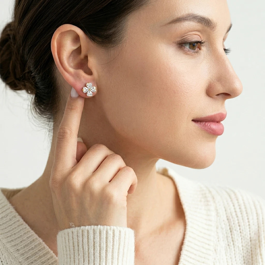 Editorial fashion lookbook portrait of a model styling timeless romantic gold heart-cut moissanite clover stud earrings.