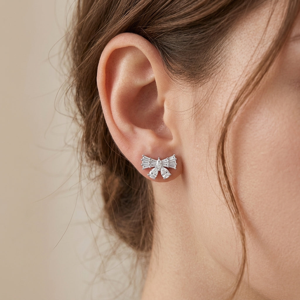 Editorial fashion lookbook portrait of a model styling timeless romantic vintage baguette moissanite bow studs with pulled-back hair.