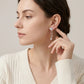Editorial fashion lookbook portrait of a model styling timeless romantic vintage butterfly moissanite evening drop earrings.