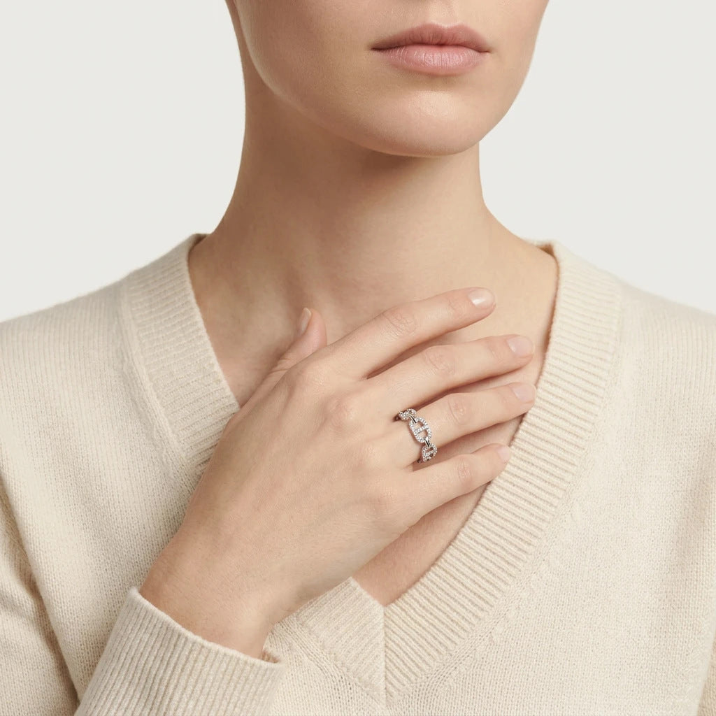 Editorial fashion lookbook portrait of a model styling a timeless romantic vintage mariner link moissanite designer ring with a white top.