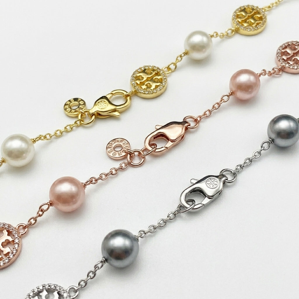 Detailed shot of the secure lobster clasp and the signature Double T logo charm on the pearl bracelet