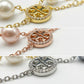 Detailed shot of the secure lobster clasp and the signature Double T logo charm on the pearl bracelet