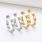 Angled profile of Tory Burch C-shaped earrings showing the open hoop structure and sleek silhouette