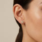 Model wearing Tory Burch Moondance Crystal Studs, showing the asymmetrical celestial look