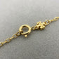 Detailed shot of the gold-tone lobster clasp and signature logo tag on the clover necklace