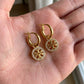 Hand-held view of Tory Burch Crystal Double T Hoops to show the actual size and scale