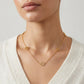 Model wearing the Tory Burch Thin Gold Logo Necklace, a perfect minimal jewelry piece