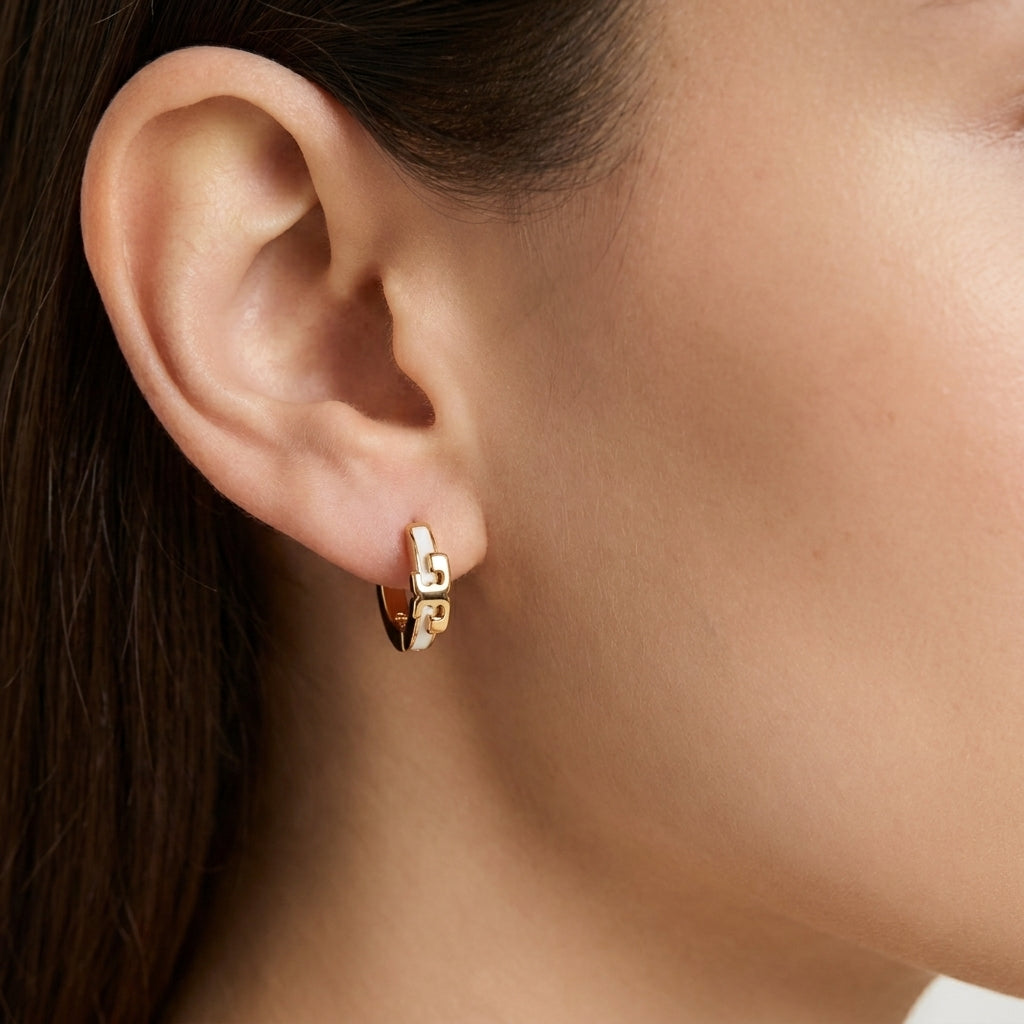 Model wearing Tory Burch Kira Enamel Huggies, showcasing a trendy jewelry stack look