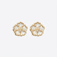 Tory Burch Forget Me Not Earrings featuring a gold floral design with the signature Double-T logo in the center.