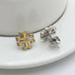 Macro detail of the high-polish gold finish and secure butterfly back closure on Tory Burch studs