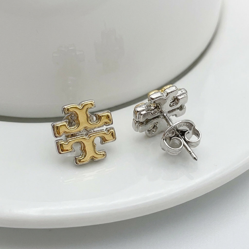 Macro detail of the high-polish gold finish and secure butterfly back closure on Tory Burch studs