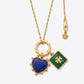 Gold necklace with heart-shaped blue pendant and green square pendant on a white background