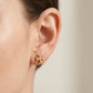 Close-up of a model wearing Tory Burch Double T Icon Stud Earrings for everyday minimalist style