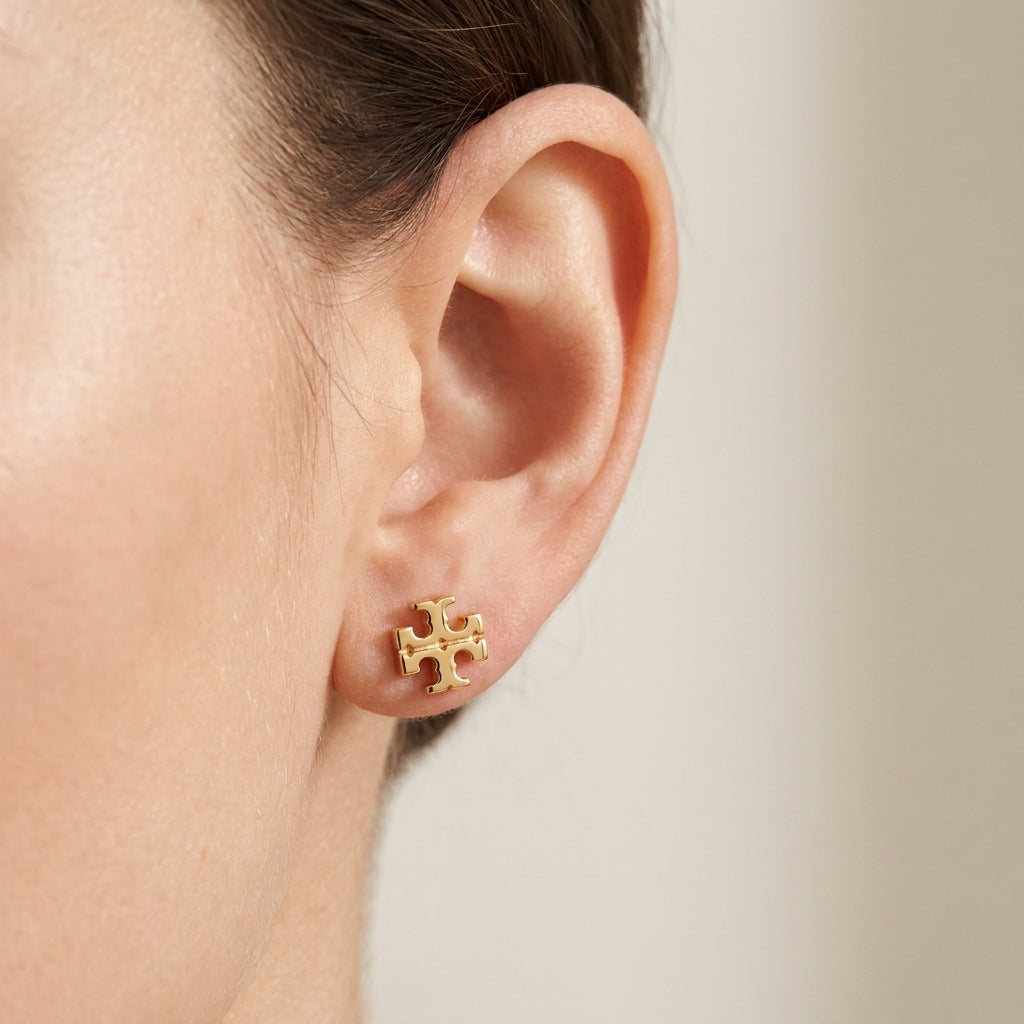 Close-up of a model wearing Tory Burch Double T Icon Stud Earrings for everyday minimalist style