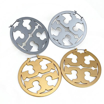 Pair of gold and silver earrings with intricate cut-out designs on a white background
