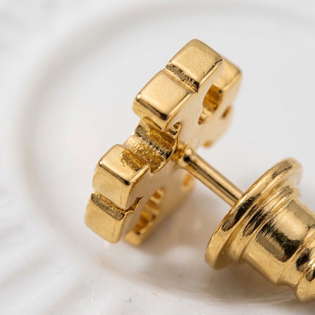 Detailed view of Tory Burch Icon Stud Earrings featuring high-polish finish and secure butterfly back
