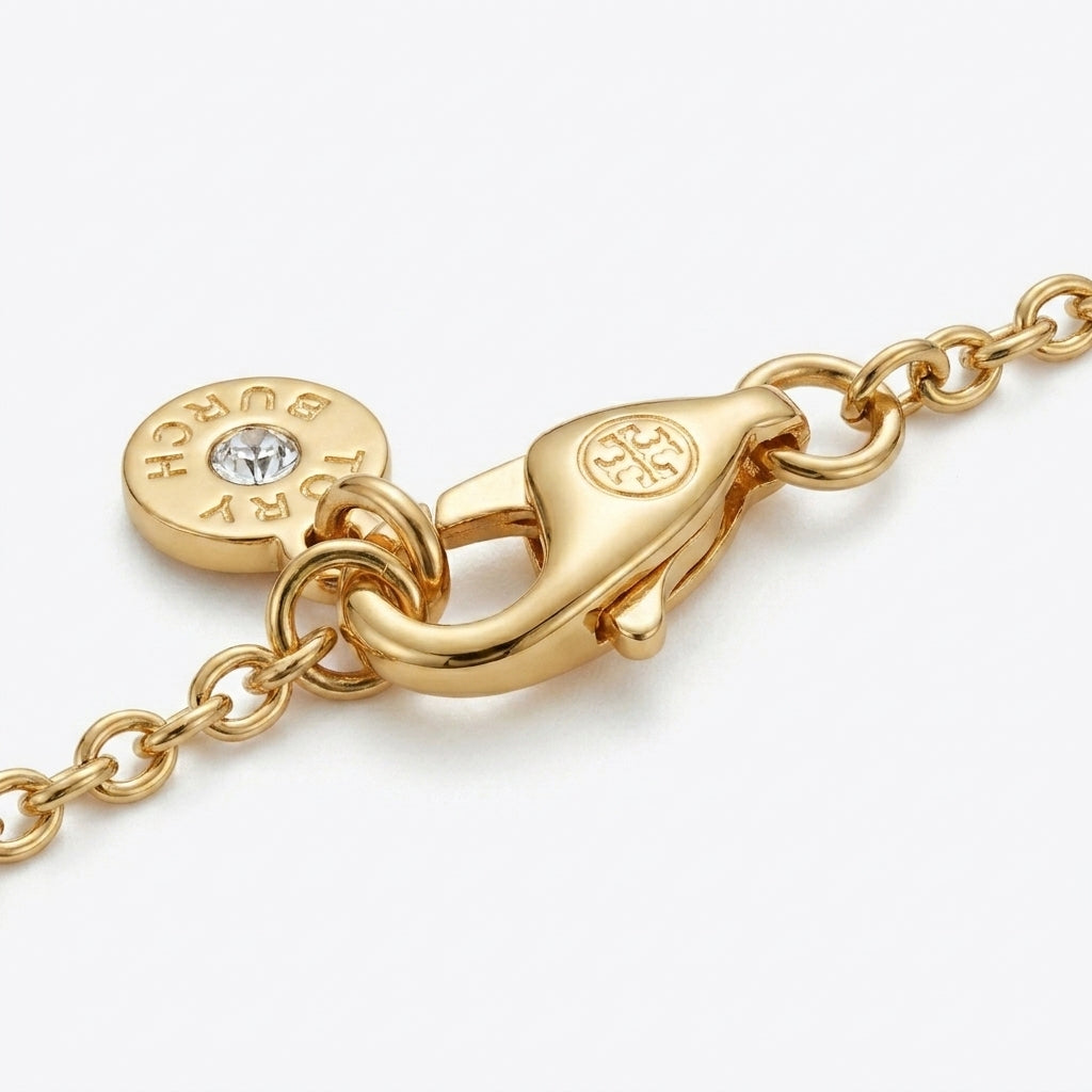 Detailed view of the lobster clasp closure and adjustable extender links of the Tory Burch Kira Enamel Bracelet.