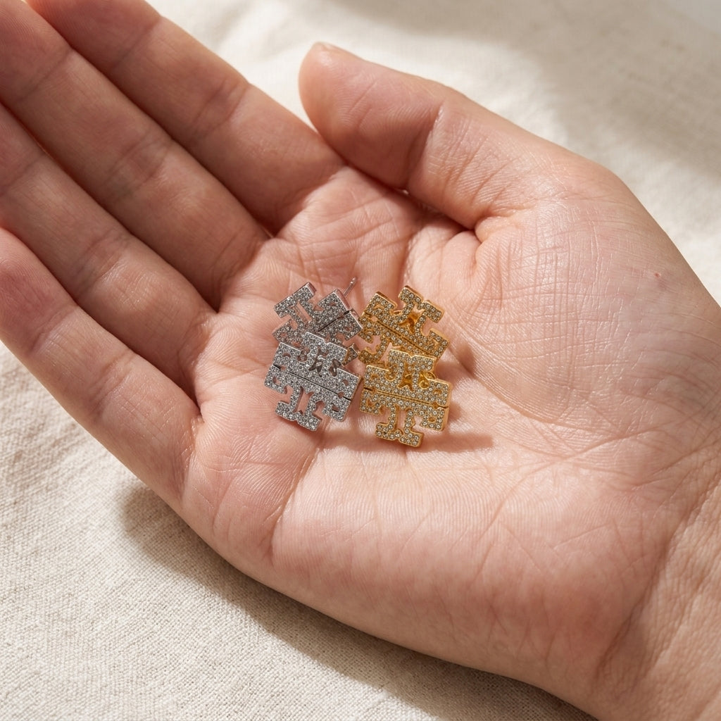Hand-held size reference of Tory Burch Kira Chevron Studs to illustrate the delicate scale