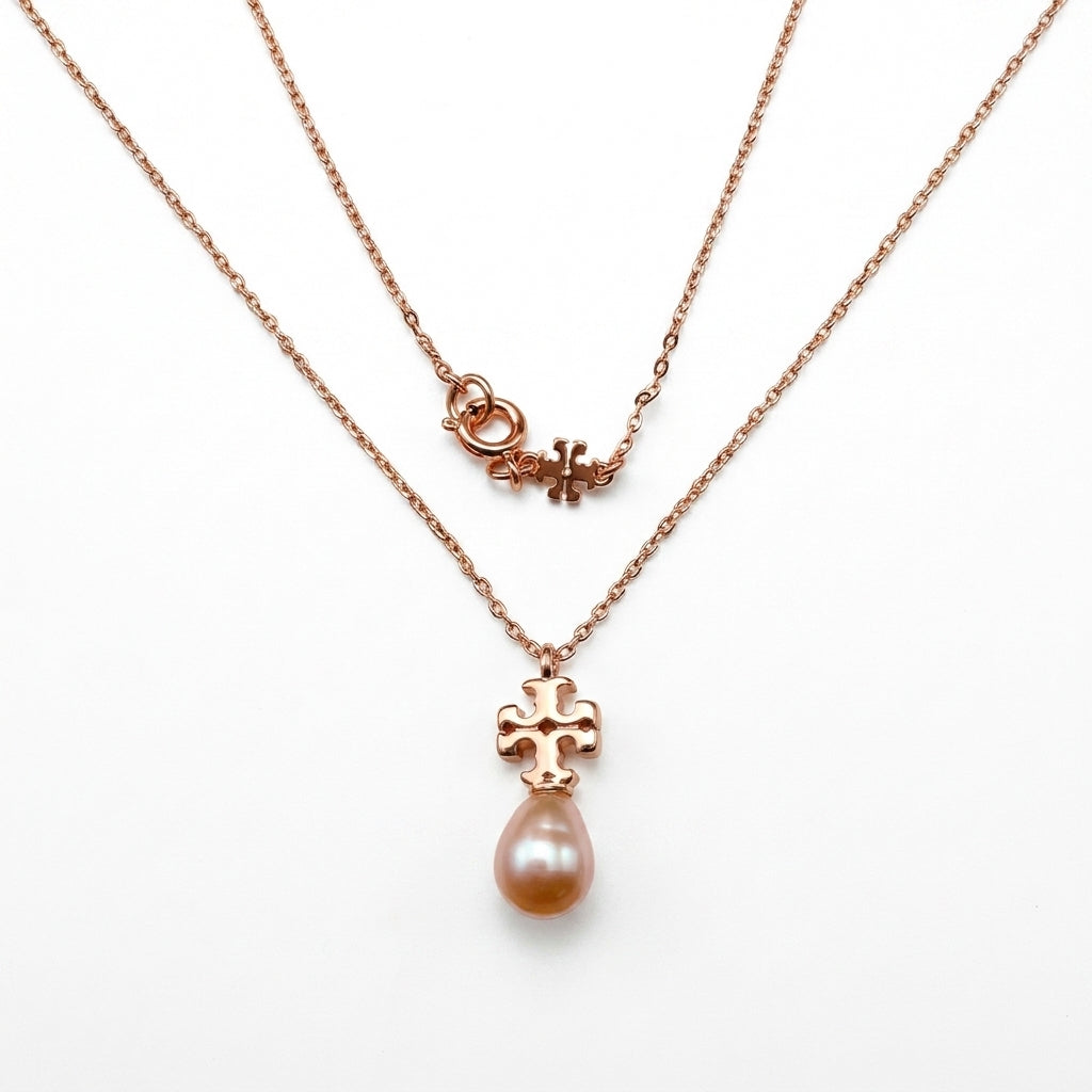 Tory Burch Kira Pearl Pendant Necklace in rose-tone featuring a Chevron-patterned Double T logobackground