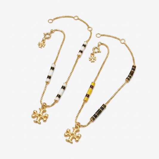 Tory Burch Kira Enamel Bar Bracelet in gold-tone with black enamel inlay and Double T logo