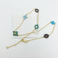 Gold chain necklace with floral-shaped charms on a white background