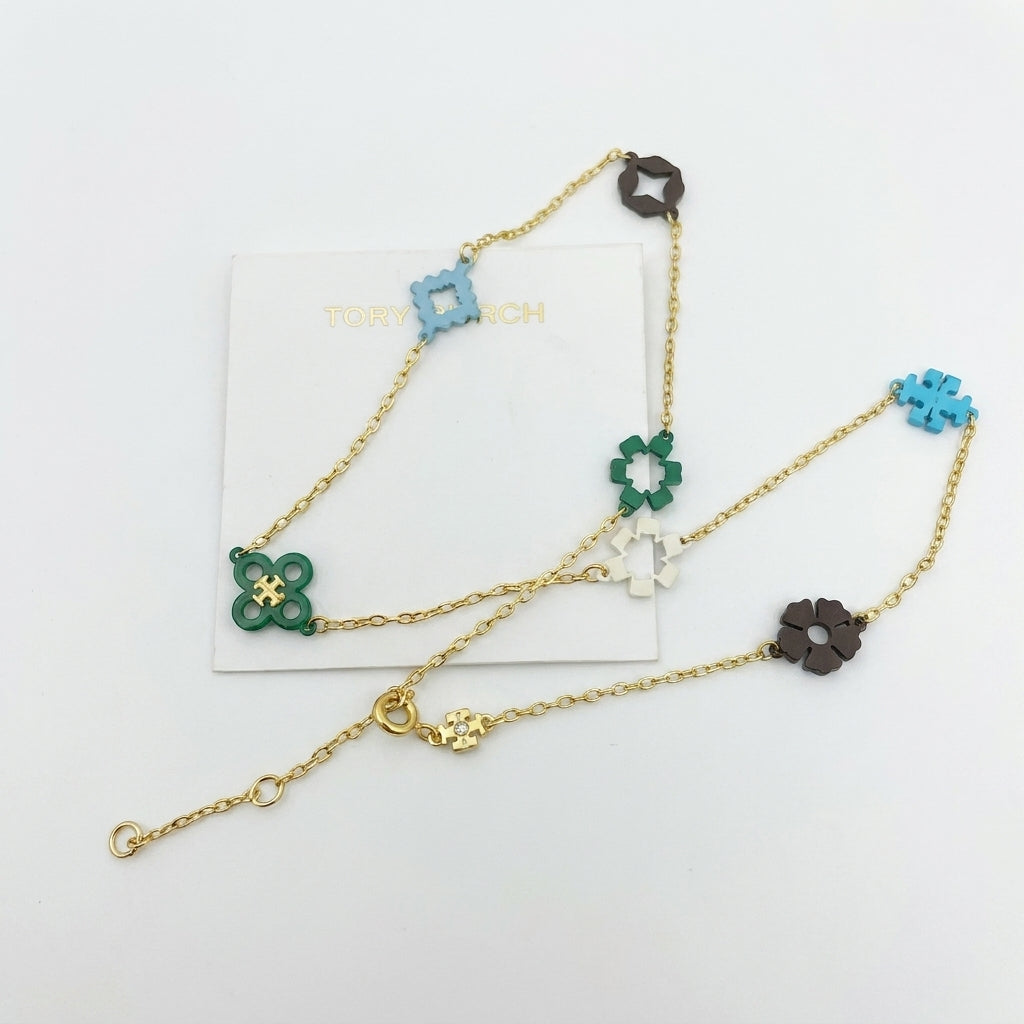 Gold chain necklace with floral-shaped charms on a white background