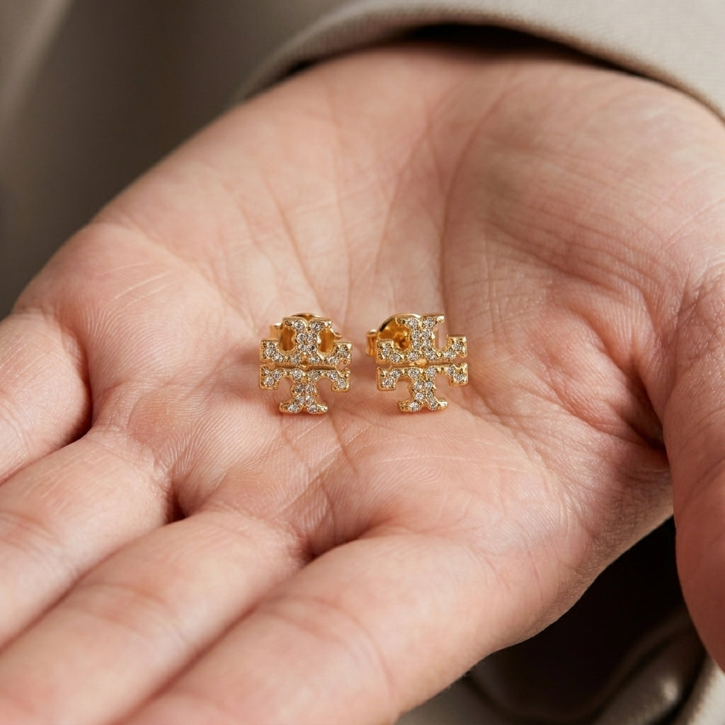 Hand-held size reference for Tory Burch Kira Pavé Studs showing the delicate scale