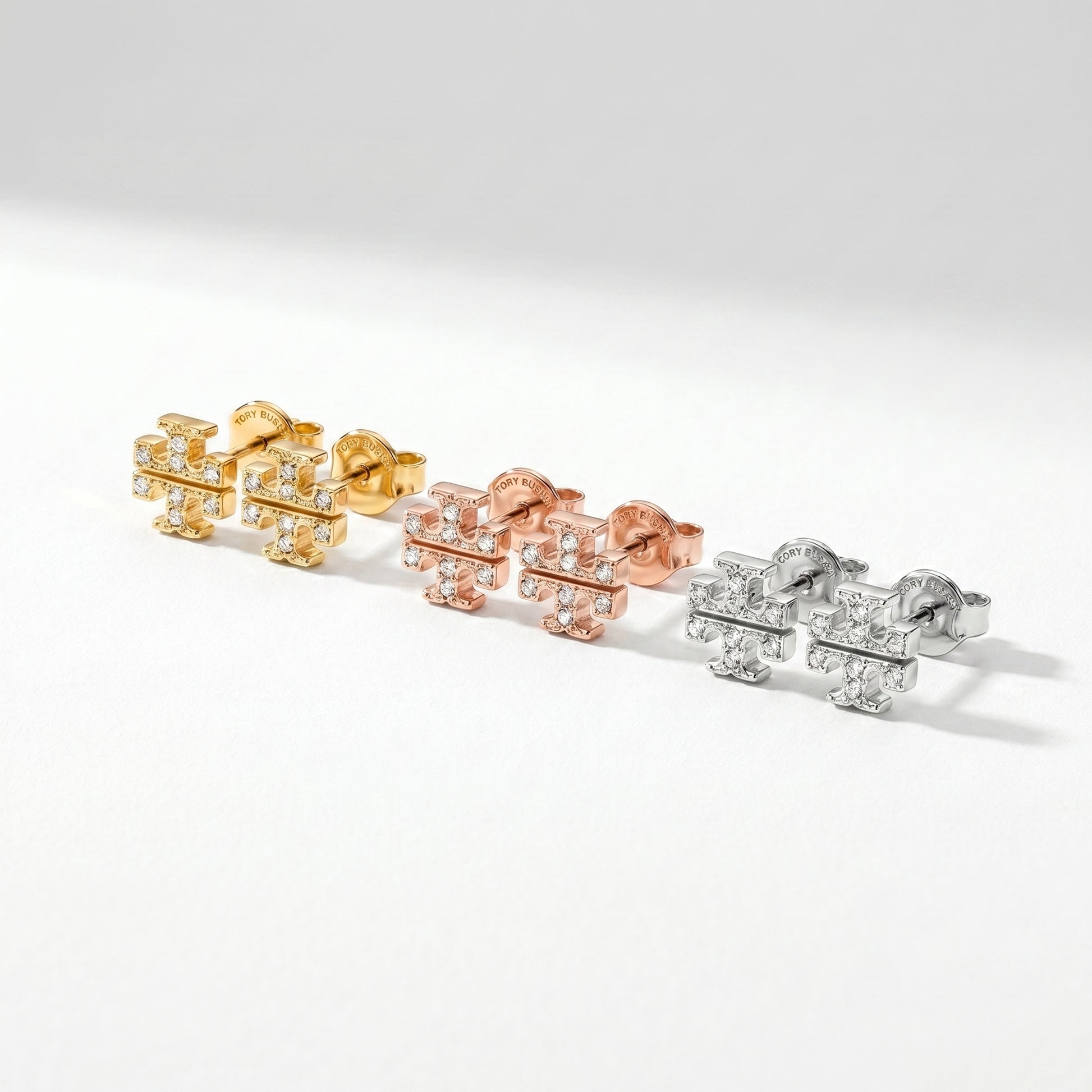 Angled side view of Tory Burch Kira Pavé Earrings showing the sturdy brass base and polished finish