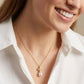 Model wearing Tory Burch Kira Chevron Pearl Necklace, an elegant choice for minimalist luxury