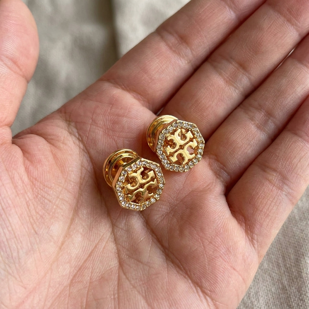 Hand-held view of Tory Burch Kira Pave Studs providing a clear size and scale reference