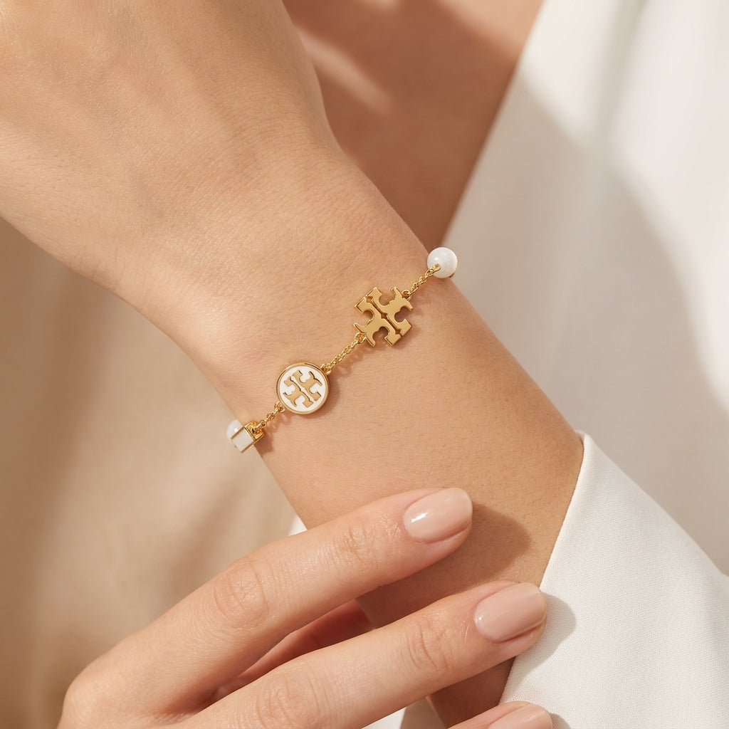 Model wearing Tory Burch TB Logo and Pearl Bracelet, a chic choice for minimalist luxury stacking