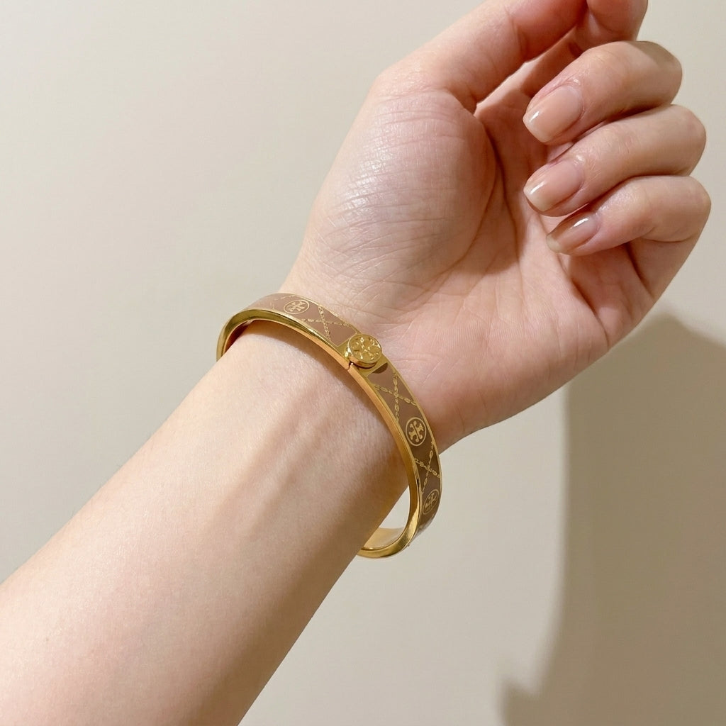 A woman wearing the Tory Burch Miller Enamel Logo Hinge Bracelet, showcasing an effortless luxury style for daily outfit.