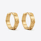 Side angled view of Tory Burch Miller Huggie Hoops showing the hinge closure and sleek hoop curve