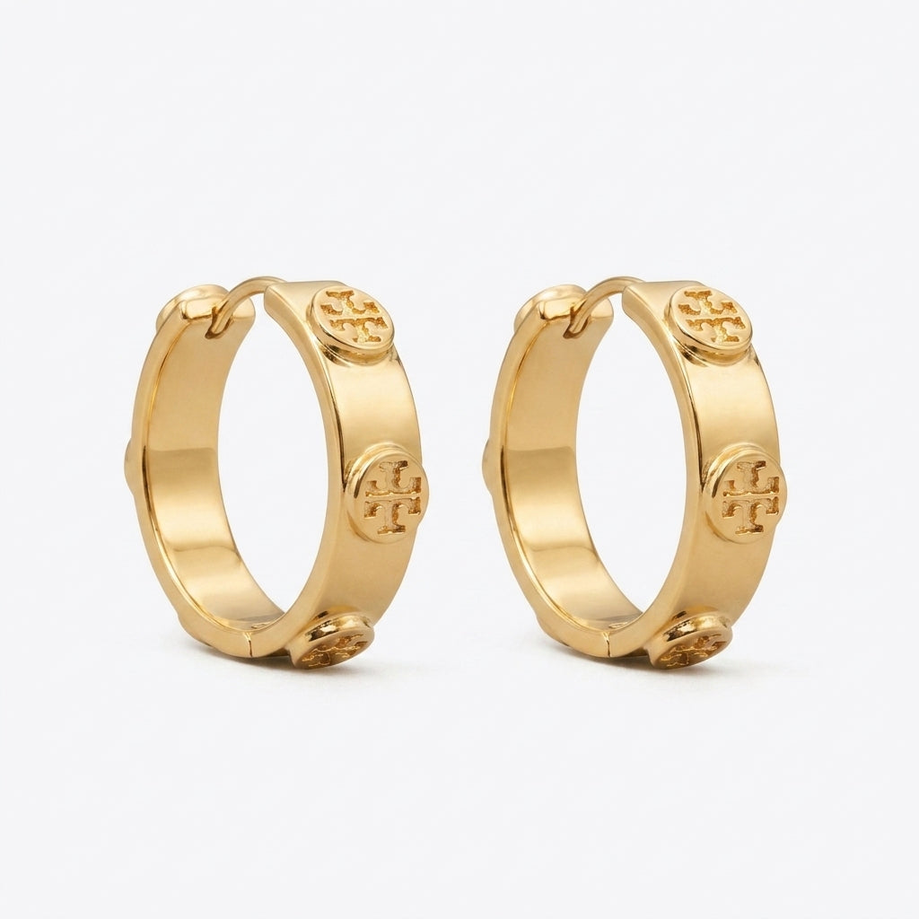 Side angled view of Tory Burch Miller Huggie Hoops showing the hinge closure and sleek hoop curve