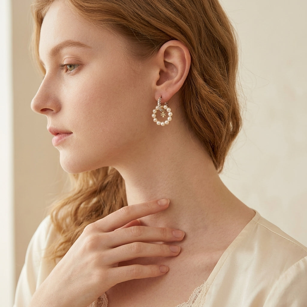 Editorial lookbook profile view of a model styling premium tory burch moondance white pearl earrings with a sleek hairstyle