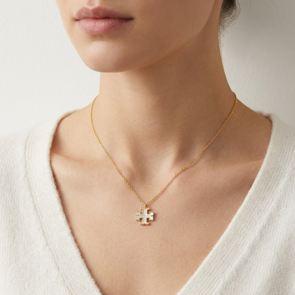 Woman wearing Tory Burch Moondance pendant necklace styled as layered minimalist gold jewelry