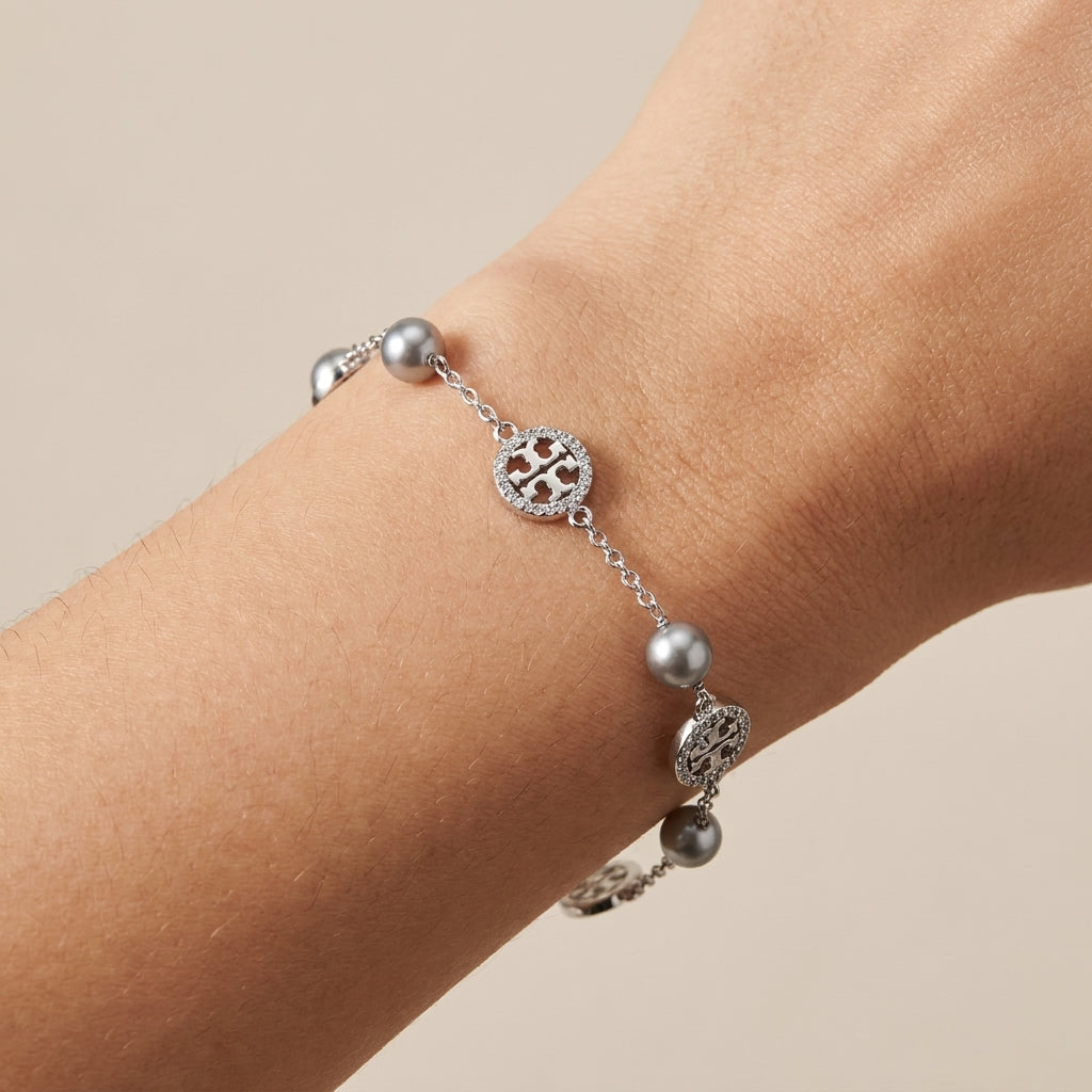 Model wearing Tory Burch Gold Pearl Bracelet, showcasing an elegant and modern jewelry look