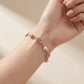 Model wearing Tory Burch Gold Pearl Bracelet, showcasing an elegant and modern jewelry look