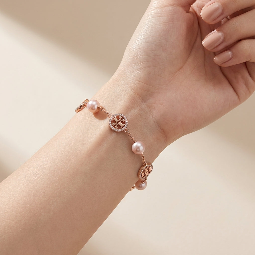 Model wearing Tory Burch Gold Pearl Bracelet, showcasing an elegant and modern jewelry look