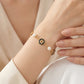 Model wearing Tory Burch Gold Pearl Bracelet, showcasing an elegant and modern jewelry look