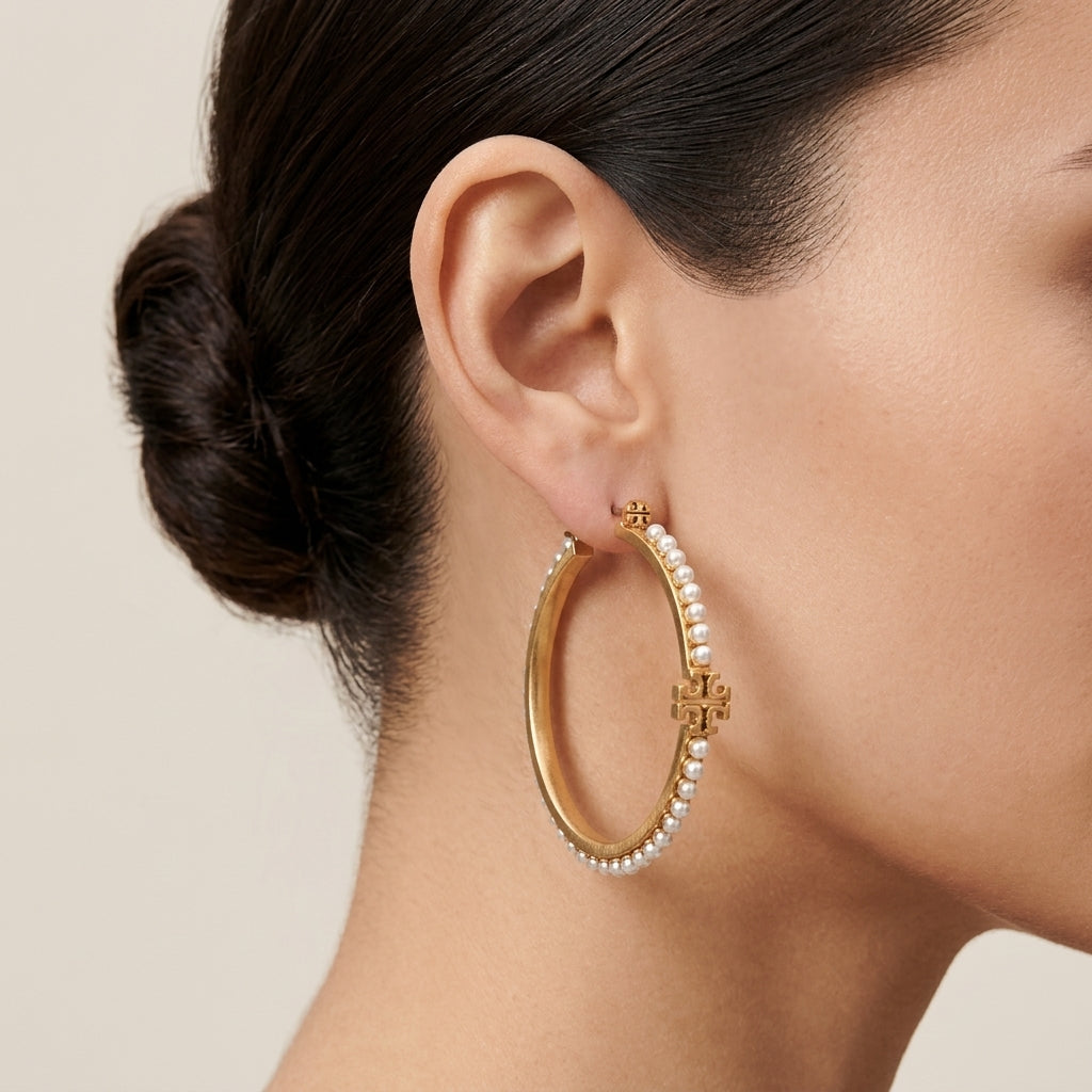 Model wearing Tory Burch Logo Pearl Hoop Earrings, demonstrating an elegant and timeless look