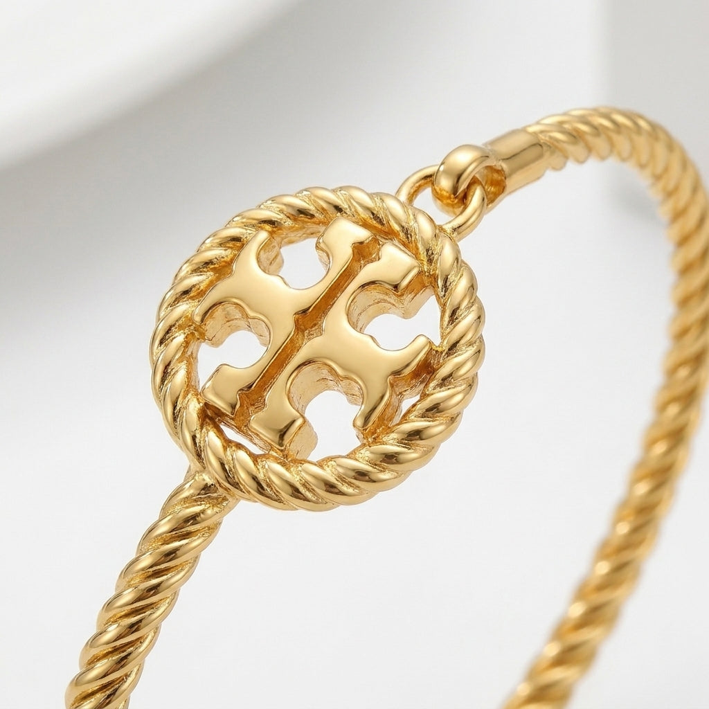 Macro detail of the high-shine gold finish and intricate twisted rope texture on the cuff