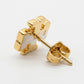 Macro shot of the vibrant enamel color and the polished gold Double T logo on small stud earrings